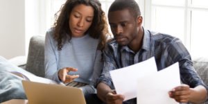 A picture of a young African-American couple reviewing financial documents