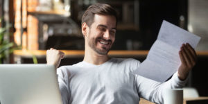 A picture of a young male celebrating good financial news