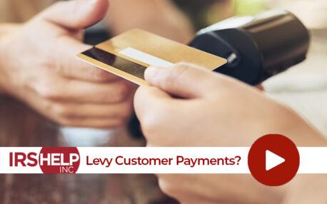 An image of a customer paying for services with a credit card in hand on a touch-free credit card reader